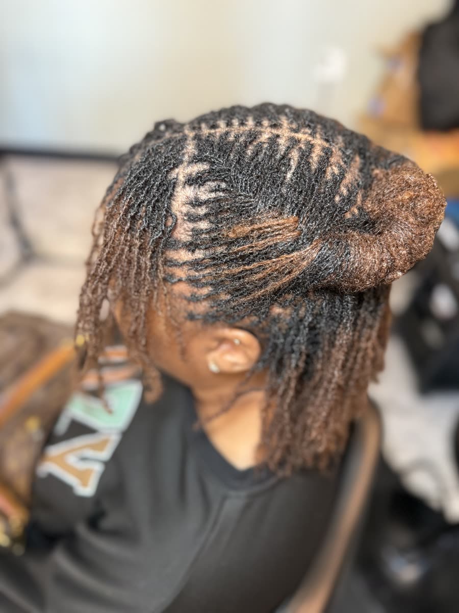 Micro locs styled in a swirl bun with color