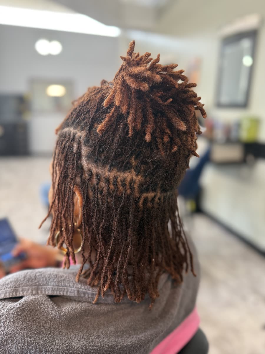 Auburn colored locs in a half-up style